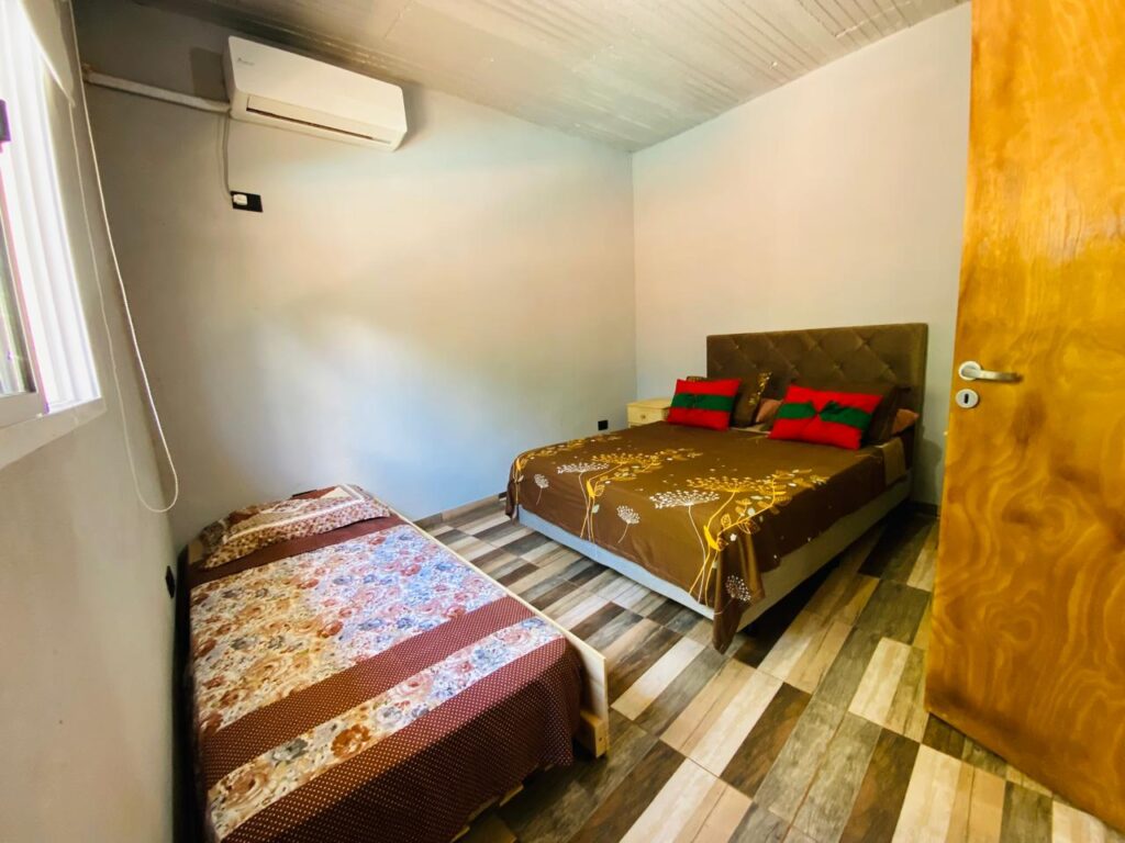 Habitación con camas y aire acondicionado en departamento Selva Iguazú