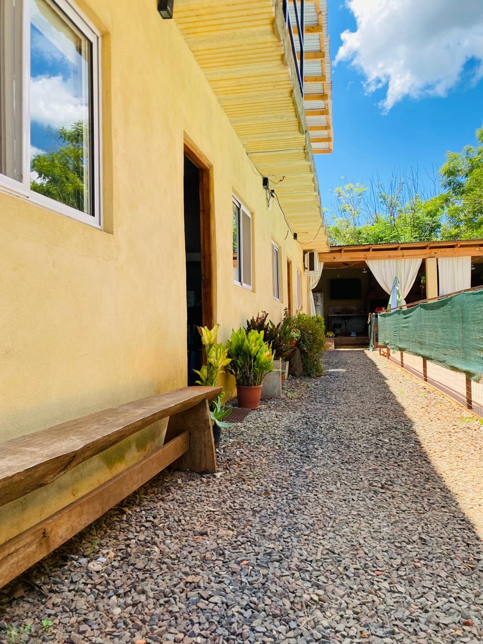 Pasillo exterior con plantas y banco de madera en Selva Iguazú Apartments